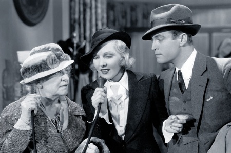 Young woman speaking into older woman's ear trumpet (black and white)