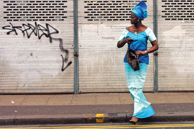 Brightly dressed woman crossing street, Peckham, London Brightly dressed woman crossing street, Peckham, London