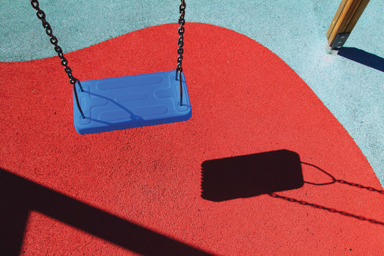 Empty swing casting shadow on floor Empty swing casting shadow on floor