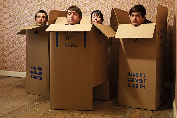 Four people sitting in cardboard boxes Four people sitting in cardboard boxes