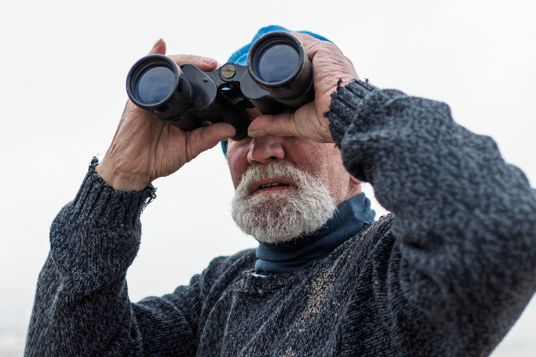 Man looking through binoculars Man looking through binoculars