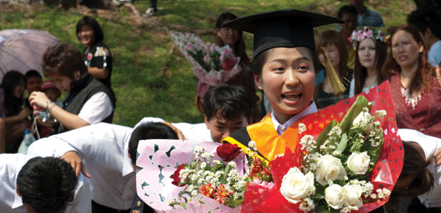 Thai female graduate holding bunches of flowers Thai female graduate holding bunches of flowers