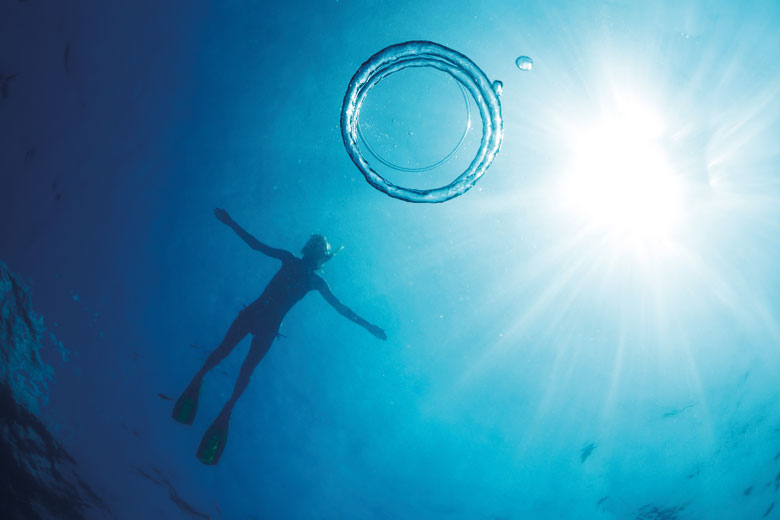 Scuba diver swimming in clear blue water Scuba diver swimming in clear blue water