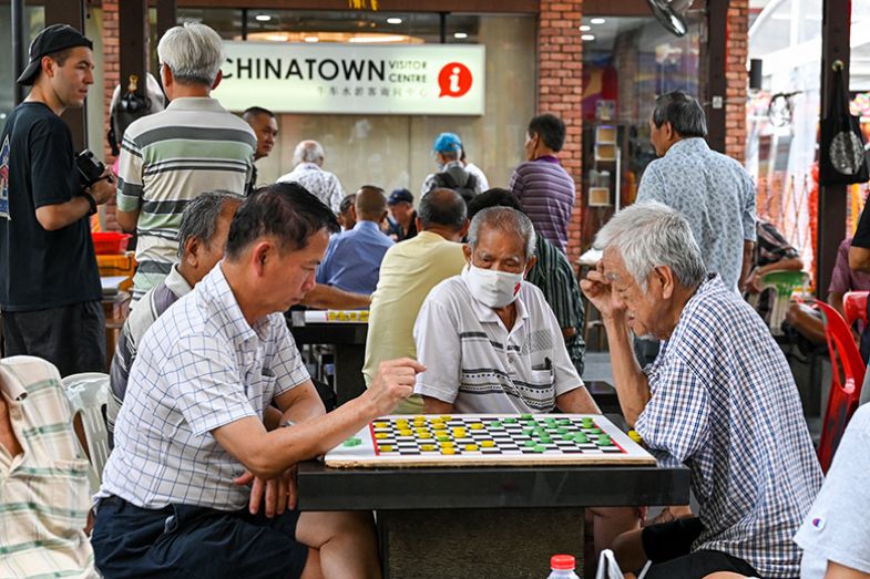 Elderly people play checkers in Singapore’s Chinatown. To illustrate the ageing population of Singapore. Elderly people play checkers in Singapore’s Chinatown. To illustrate the ageing population of Singapore.