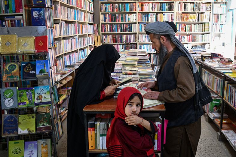 An Afghan woman browses a book at a bookstore in Mazar-i-Sharif, Afghanistan on 27 April 2025.