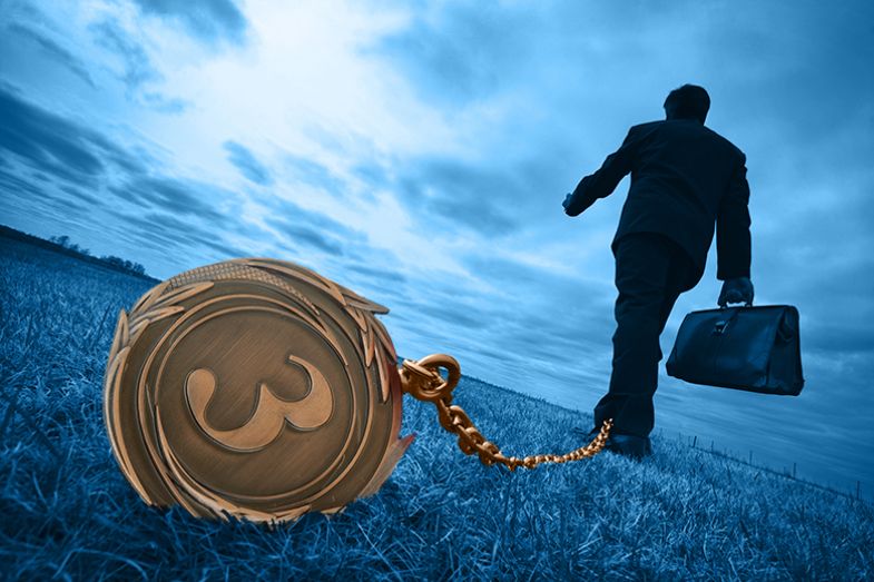 Man walking with bronze medal acting as ball and chain. To illustrate that a Bronze rating under the Teaching Excellence Framework could be a burden for universities. Man walking with bronze medal acting as ball and chain. To illustrate that a Bronze rating under the Teaching Excellence Framework could be a burden for universities.