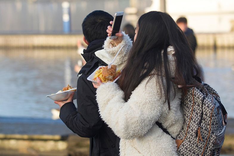 woman eating chips and taking a photo woman eating chips and taking a photo