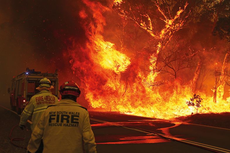 Fire and Rescue personnel run to move their truck as a bushfire burns near the town of Bilpin Fire and Rescue personnel run to move their truck as a bushfire burns near the town of Bilpin