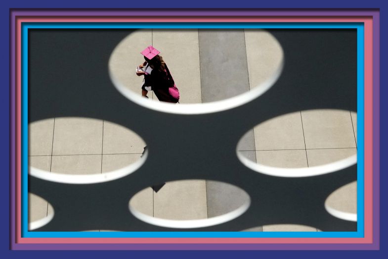 A graduate is seen through holes, Walnut, California, USA. As an illustration of holes in admissions to universities caused by demographic decline.