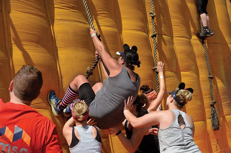 Contestants climb an inflatable wall during the 2019 Strongman obstacle race, in Paarl, near Cape Town. Contestants climb an inflatable wall during the Strongman obstacle race in 2019, in Paarl, near Cape Town. Symbolising helping up black postgrads