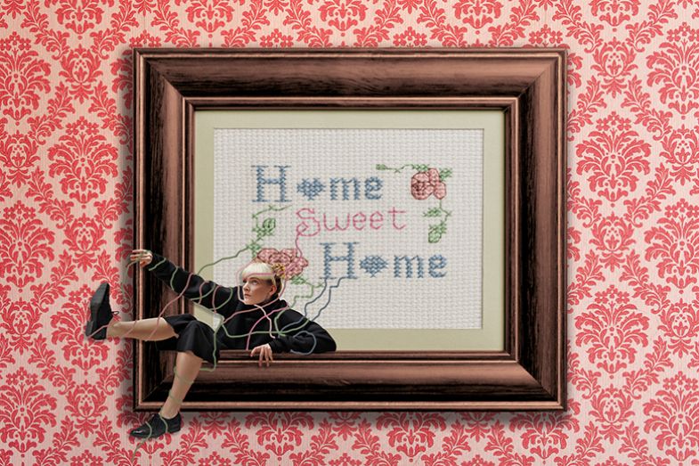 A student trapped by thread coming from a Home Sweet Home picture on the wall. To illustrate that due to the cost of university many students need to live at home, often missing out on experiences on campus. A student trapped by thread coming from a Home Sweet Home picture on the wall. To illustrate that due to the cost of university many students need to live at home, often missing out on experiences on campus.