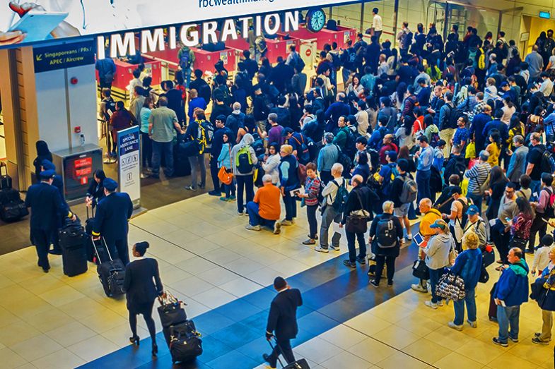 High-angle view of a crowd of people in arrivals immigration queue at Changi airport, Singapore, with a separate entrance for Singaporeans High-angle view of a crowd of people in arrivals immigration queue at Changi airport, Singapore, with a separate entrance for Singaporeans