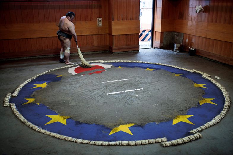 Sumo wrestler sweeping the ring to expose a Japanese flag among the stars of the EU flag. To illustrate Japan participating in Horizon Europe, but needing to be mindful of Japanese priorities.