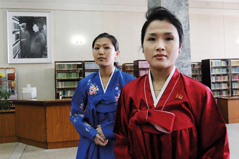 North Korean librarians next to a portrait of Kim Jong-Il North Korean librarians next to a portrait of Kim Jong-Il