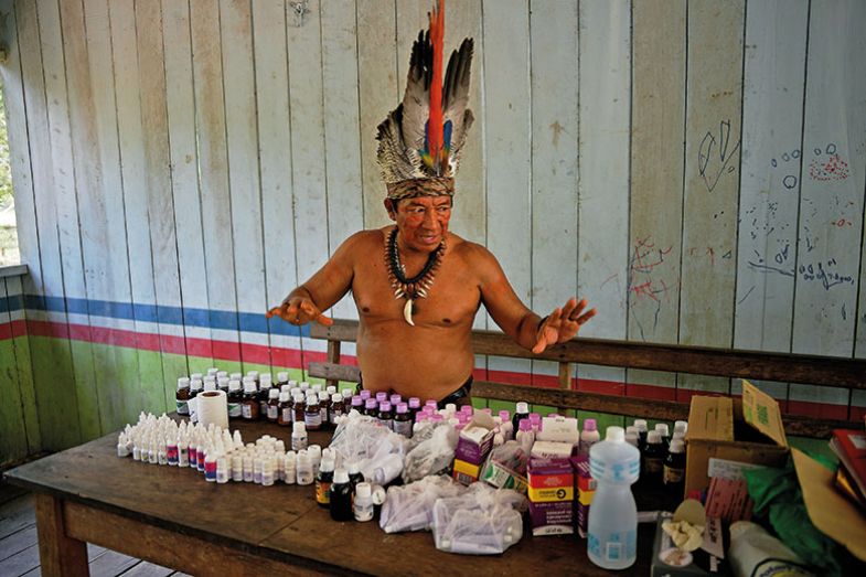 Chief Marcelino Apurina, of the Aldeia Novo Paraiso in the Western Amazon region of Brazil near Labrea, stands by a table of modern medicines delivered to the village on September 21, 2017 Chief Marcelino Apurina, of the Aldeia Novo Paraiso in the Western Amazon region of Brazil near Labrea, stands by a table of modern medicines delivered to the village on September 21, 2017