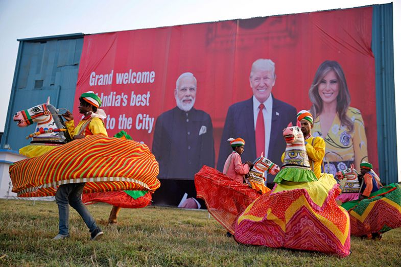 Indian folk dancers rehearse their performance next to a billboard featuring Indian prime minister Narendra Modi, US president Donald Trump and first lady Melania Trump, illustrating the two leaders’ similar attitudes towards higher education.
