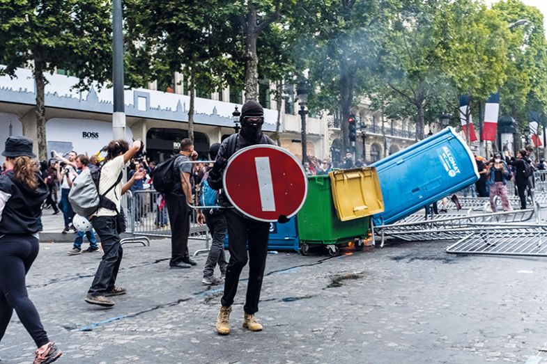 A demonstrator holds a STOP sign as a shield during gilets jaunes protests on the Champs-Elysees A demonstrator holds a STOP sign as a shield during gilets jaunes protests on the Champs-Elysees