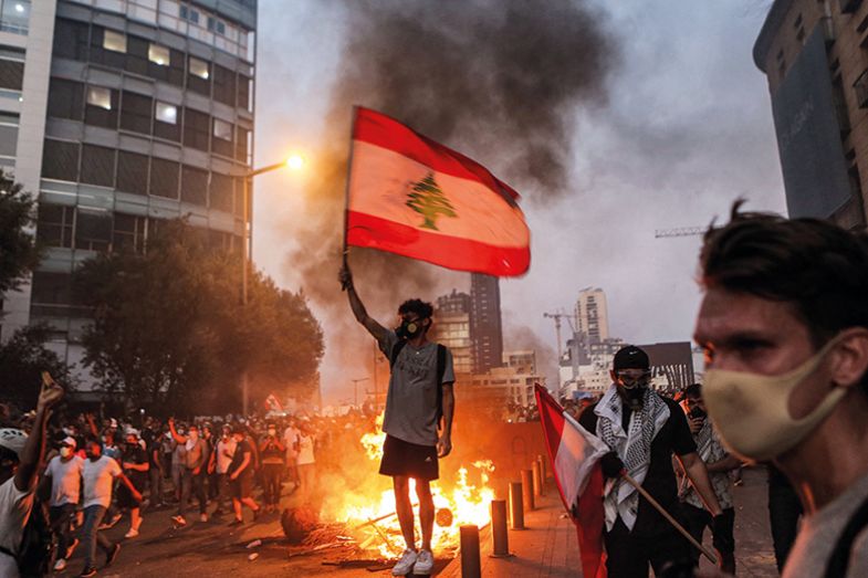 Protester stands with a Lebanese national flag Protester stands with a Lebanese national flag