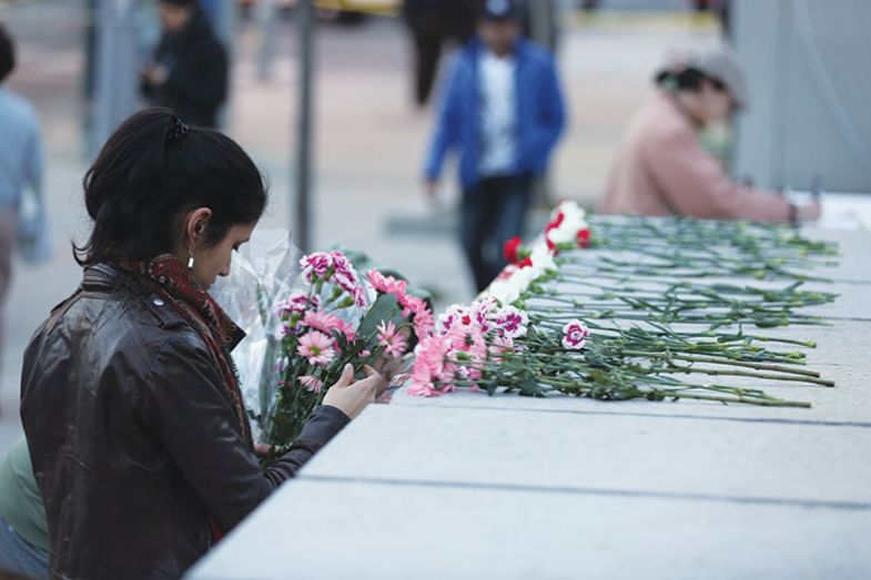 Victims of brutal violence: a woman lays flowers at a memorial set up after incel Alek Minassian drove a van into pedestrians in Toronto in 2018, killing 10 and injuring 16