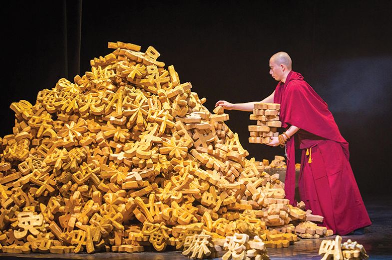 A Buddhist monk stacks models of Chinese characters from a large pile A Buddhist monk stacks models of Chinese characters from a large pile