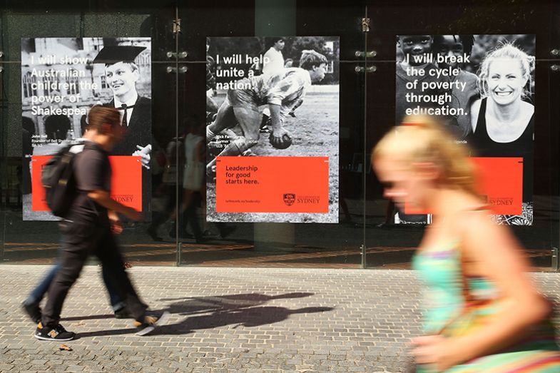 Students walk in front of posters promoting the University of Sydney at the campus on 6 April 2016 in Sydney, Australia.