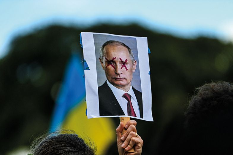 A demonstrator holds a sign depicting Russian President Vladimir Putin with eyes crossed out during a rally in support of Ukraine A demonstrator holds a sign depicting Russian President Vladimir Putin with eyes crossed out during a rally in support of Ukraine