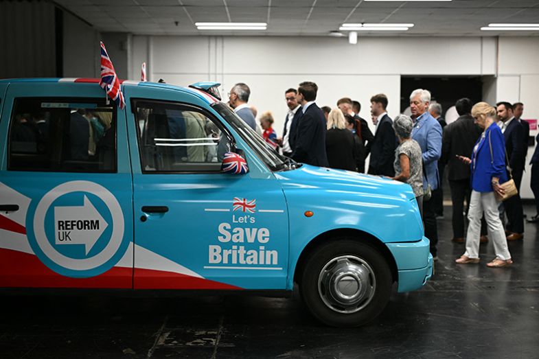 Delegates arrive alongside a Reform-branded taxi on the first day of the Reform UK annual conference at the NEC Birmingham on 5 September 2025