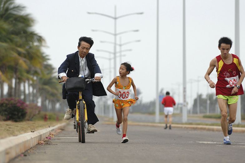 girl runs beside man on bike girl runs beside man on bike