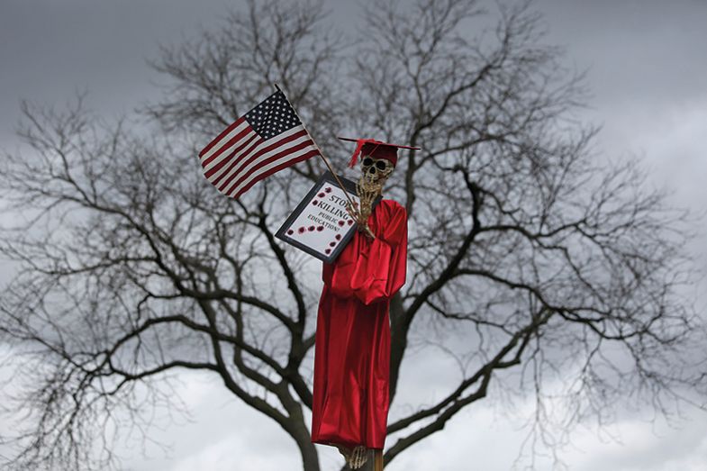 Skeleton in an academic gown holding a flag and placard Skeleton in an academic gown holding a flag and placard