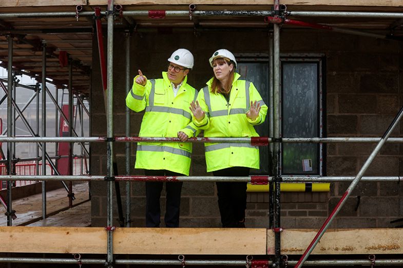 Britain’s prime minister Keir Starmer (L) and Britain’s deputy prime minister and levelling up, housing and communities secretary Angela Rayner speak together as they visit a construction site in Cambridgeshire, east England, on 12 December 2024.