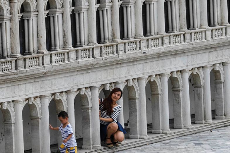 A woman poses near the Venetian Saint Mark's Square miniature in the theme park "Window Of The World" in Shenzhen, Guangdong province, China, October 20, 2014 A woman poses near the Venetian Saint Mark's Square miniature in the theme park "Window Of The World" in Shenzhen, Guangdong province, China, October 20, 2014