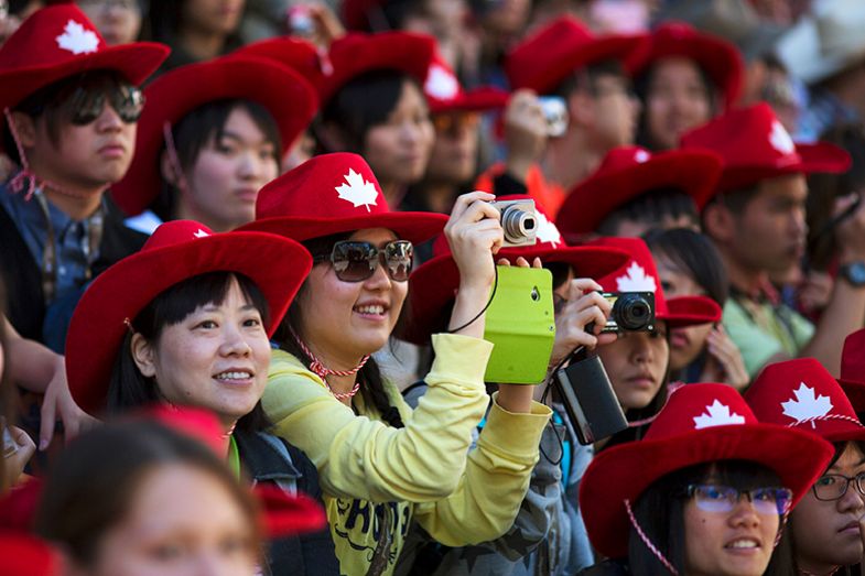 Tourists from Taiwan take photos during the Calgary Stampede parade in Calgary, Alberta, Canada.