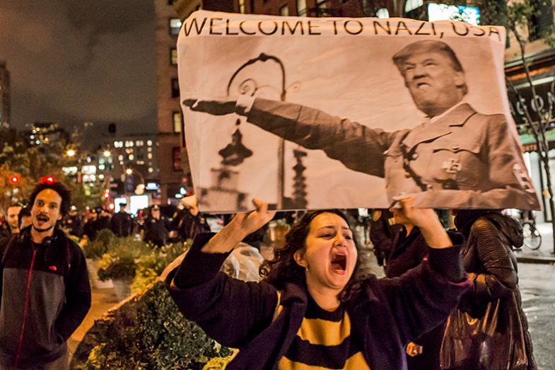 A woman holds a placard portraying Donald Trump as a Nazi, as various protests gathered in and around Manhattan and eventually marched through the streets, wending their way to Trump Tower, 9 September 2016 A woman holds a placard portraying Donald Trump as a Nazi, as various protests gathered in and around Manhattan and eventually marched through the streets, wending their way to Trump Tower, 9 September 2016
