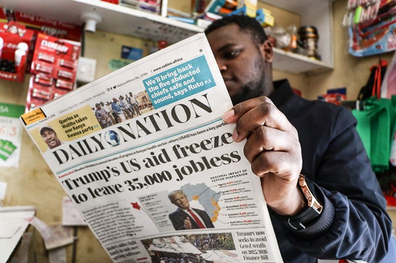 A man reads a newspaper reporting the impact of the US government aid freeze on Kenya A man reads a newspaper reporting the impact of the US government aid freeze on Kenya