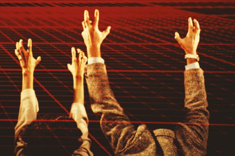 A man and a woman stretch out their arms toward a red computerised grid A man and a woman stretch out their arms toward a red computerised grid