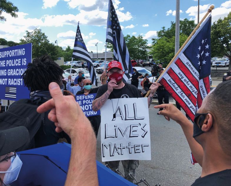 Protestors argue with a counter protester holding an "all lives matter" sign Protestors argue with a counter protester holding an "all lives matter" sign