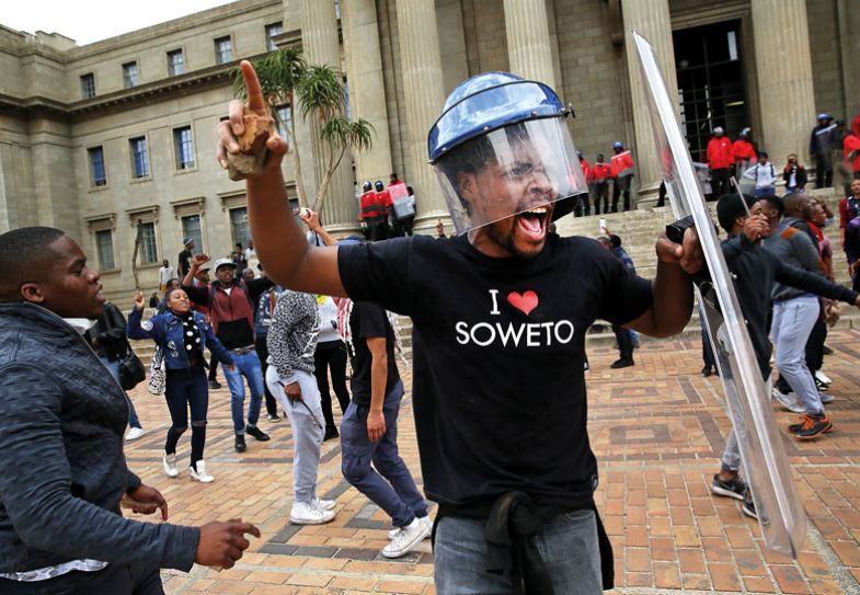 A Wits University student leader Mcebo Dlamini, wearing a security guards helmet and holding a shield A Wits University student leader Mcebo Dlamini, wearing a security guards helmet and holding a shield