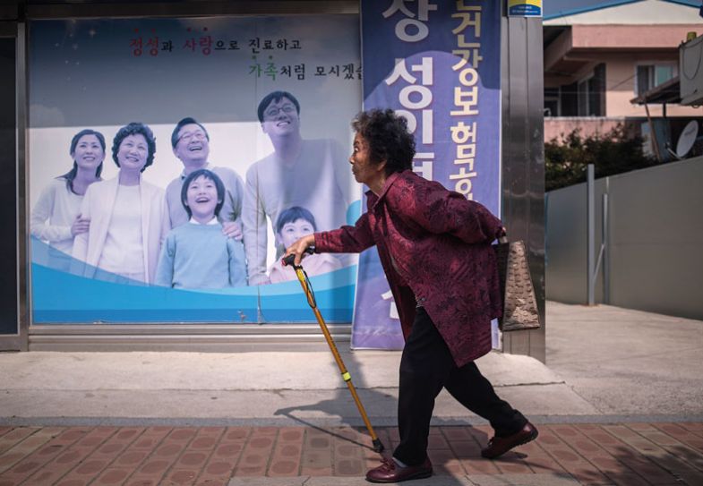 An elderly woman walks past a poster at a health centre in Gunwi An elderly woman walks past a poster at a health centre in Gunwi