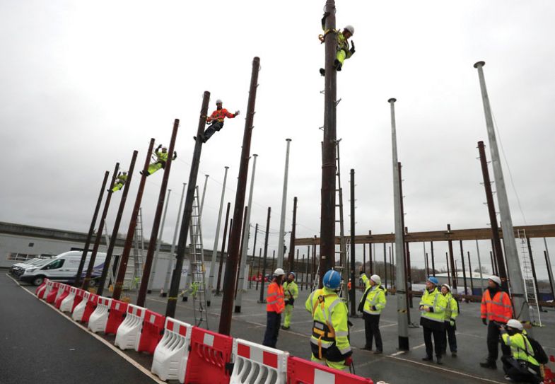 Britain's Prime Minister Boris Johnson (C) watches a demonstration from an apprentice in the pole field during a visit to the Openreach Learning and Development Training Centre in Bolton, Greater Manchester Britain's Prime Minister Boris Johnson (C) watches a demonstration from an apprentice in the pole field during a visit to the Openreach Learning and Development Training Centre in Bolton, Greater Manchester