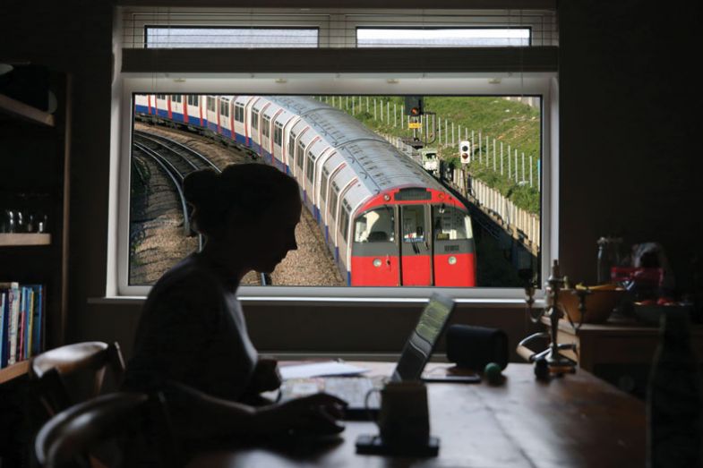 Person from home with a tube train outside the window. Person from home with a tube train outside the window.
