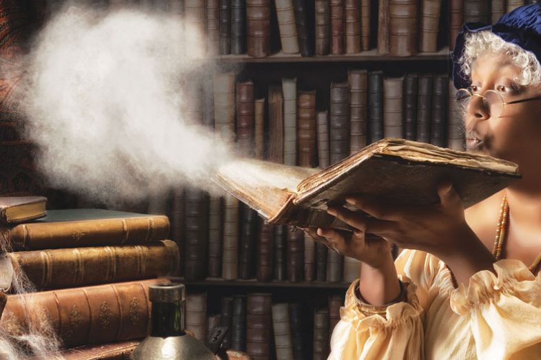 Medieval alchemist blowing dust off an old book Medieval alchemist blowing dust off an old book