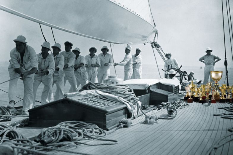 Thomas Octave Murdoch Sopwith (l), the British aviator, aircraft designer and sportsman, on his yacht the Endeavour with his crew, at Cowes, Isle of Wight with gold trophy cups