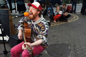 A man playing a guitar and singing A man playing a guitar and singing