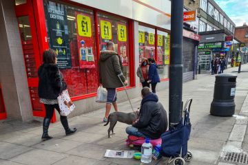 Begging outside the entrance of a supermarket
