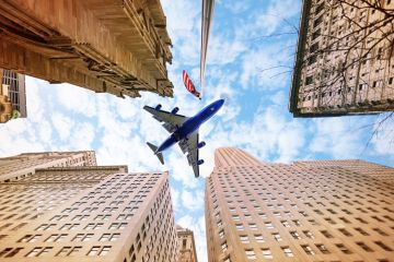 An aeroplane flies over American skyscrapers