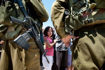 Al-Walaja, Occupied Palestinian Territories - August 27, 2011 A Palestinian girl confronts Israeli soldiers in a protest against the encirclement of the West Bank town of Al-Walaja by the Israeli separation barrier. Al-Walaja, Occupied Palestinian Territories - August 27, 2011 A Palestinian girl confronts Israeli soldiers in a protest against the encirclement of the West Bank town of Al-Walaja by the Israeli separation barrier.