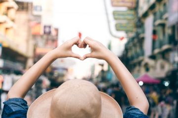 Asian traveller woman hand with heart gesture for love