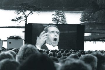Audience watching opera singer on large screenq Audience watching opera singer on large screen