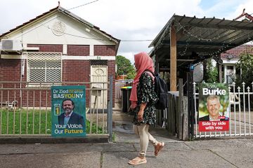 A woman walks past campaign signs depicting candidates in Lakemba, Australia, 12 March 2025. A woman walks past campaign signs depicting candidates in Lakemba, Australia, 12 March 2025.