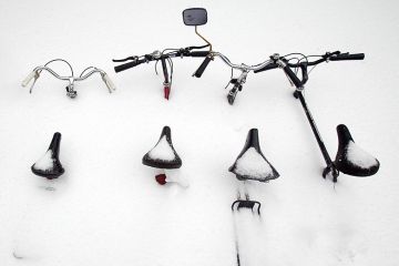 Bicycles are buried in snow in Montreal, Canada. To illustrate that the flow of international students to Canada is declining.